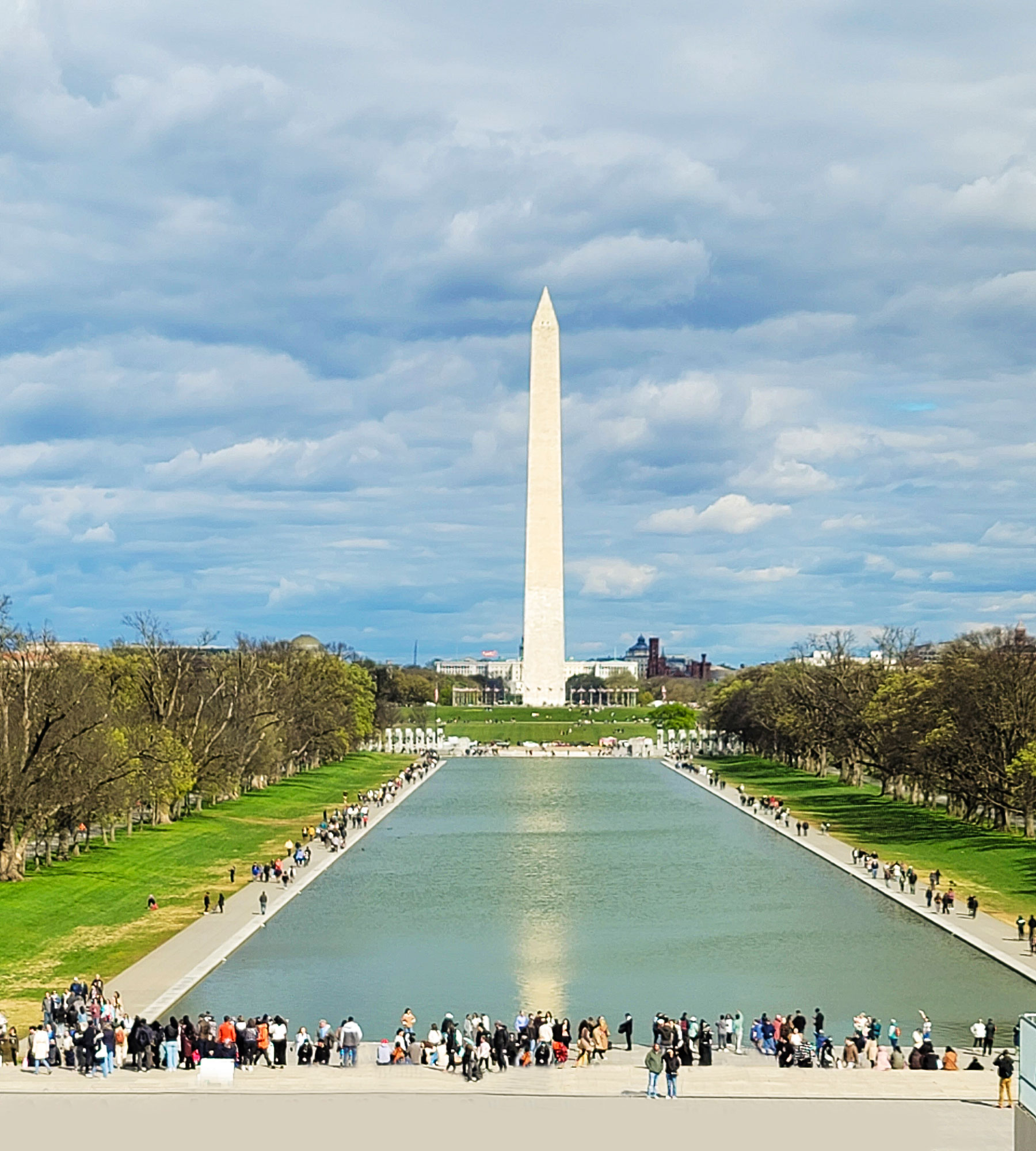 View looking down the reflecting pool at the Washington Monument on a sunny day